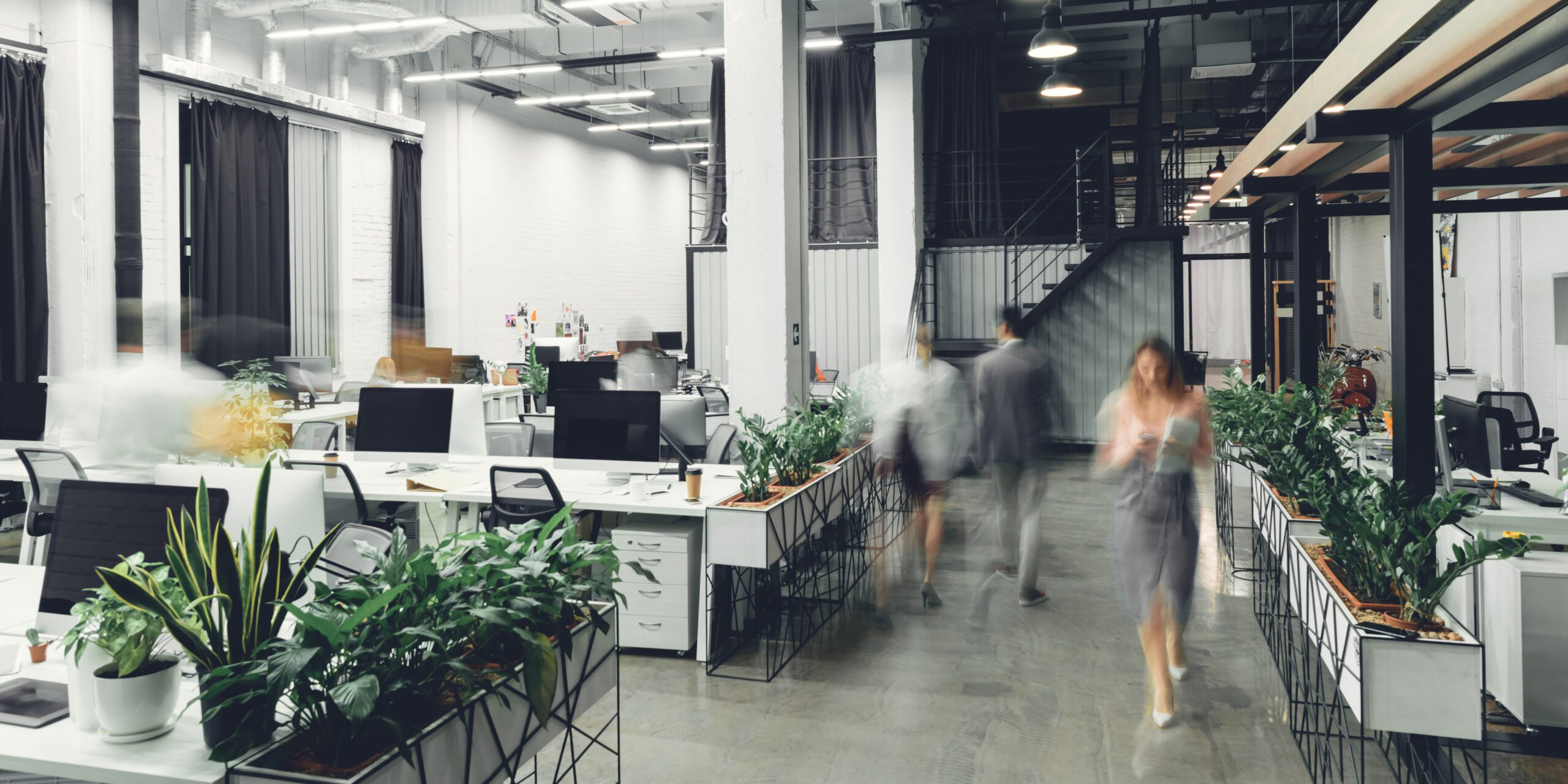a Long exposure photo of people walking around an open plan office